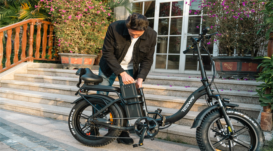 Man checking the battery of his black folding electric bicycle
