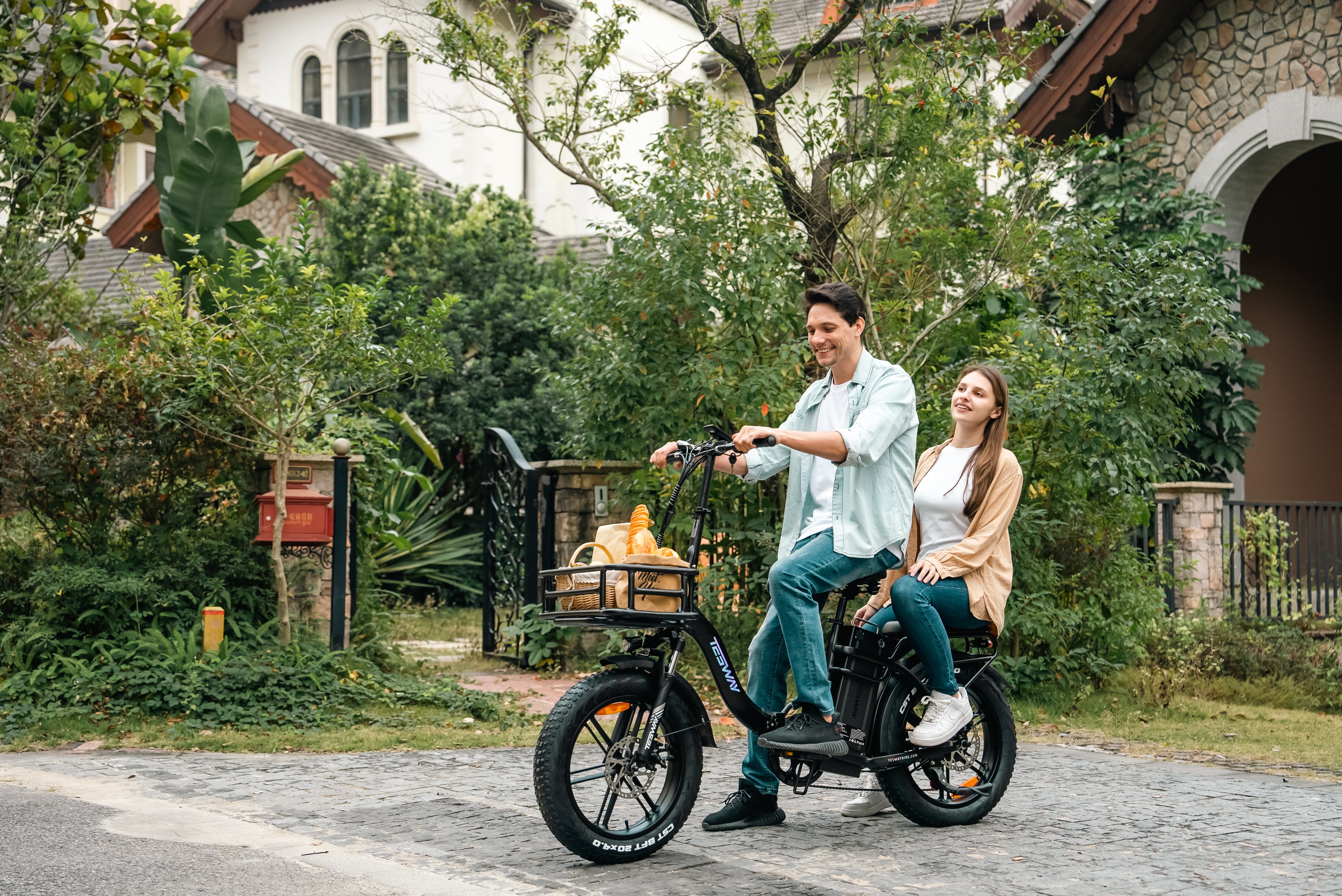 A man rides a Tesway S5 folding electric bicycle with his wife on the back seat